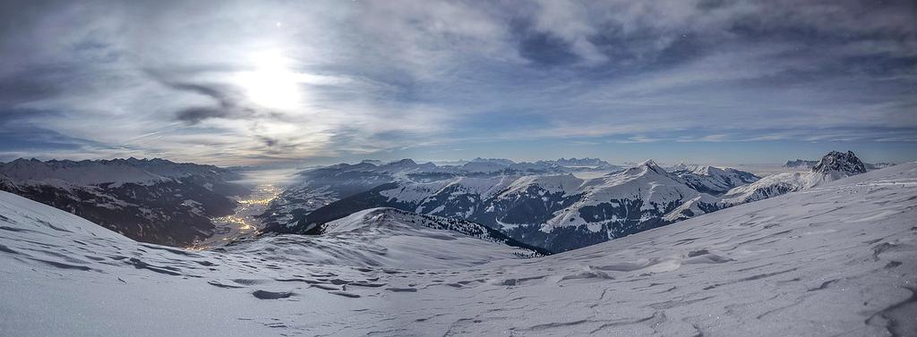 Traveler sitting on a mountain peak enjoying sunrise view